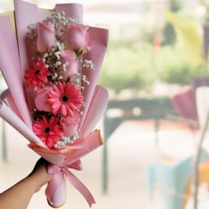 foto de una mano sosteniendo un ramo de rosas y margaritas